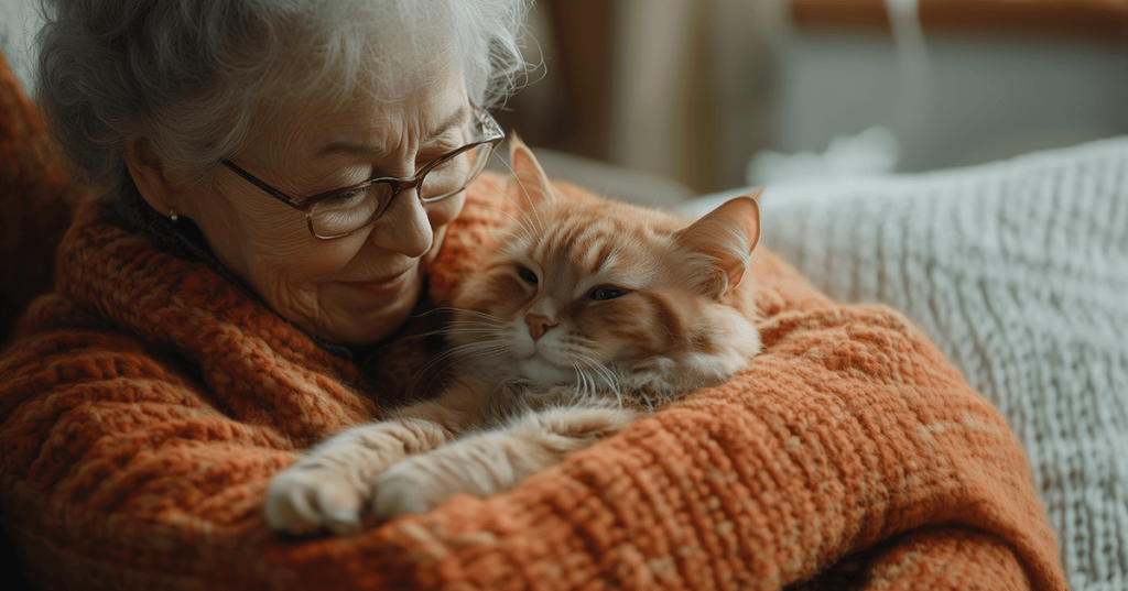 older woman with orange sweater holding orange cat shows how pets for the elderly can be beneficial
