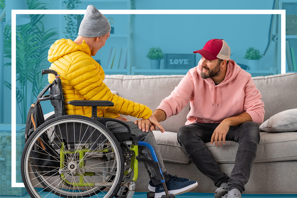 Man in a wheelchair chats with another man on a sofa in a comfortable living room
